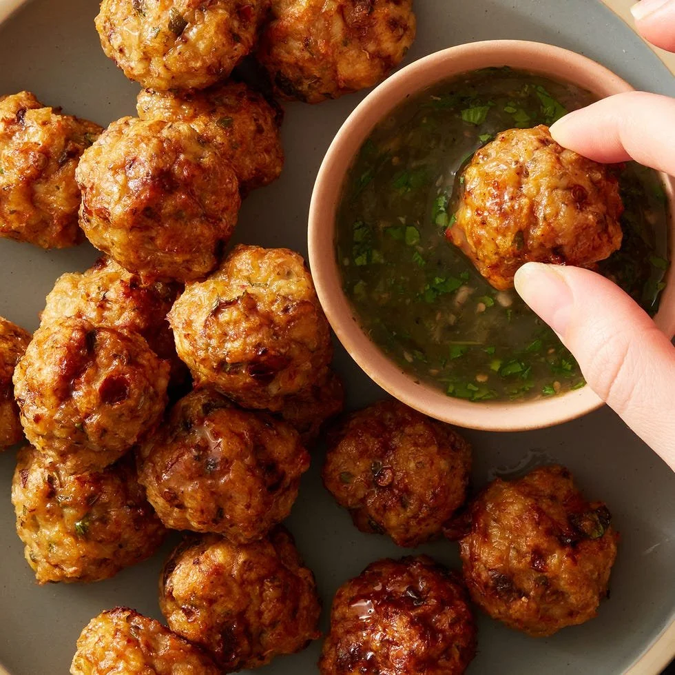Air Fryer Chipotle Chicken Meatballs served with herbs and sauce.