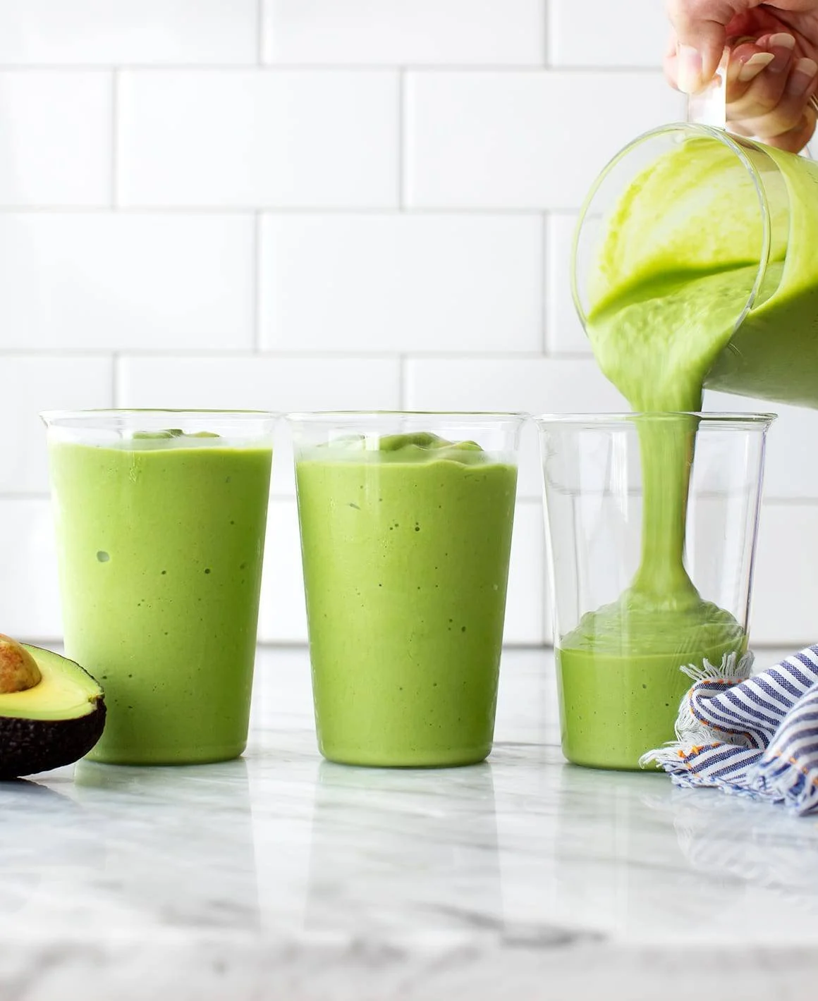 Creamy avocado smoothie in a glass with fresh avocado slices