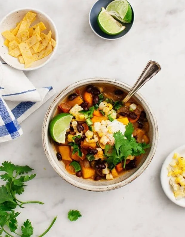A bowl of delicious vegan chili topped with avocado and cilantro.