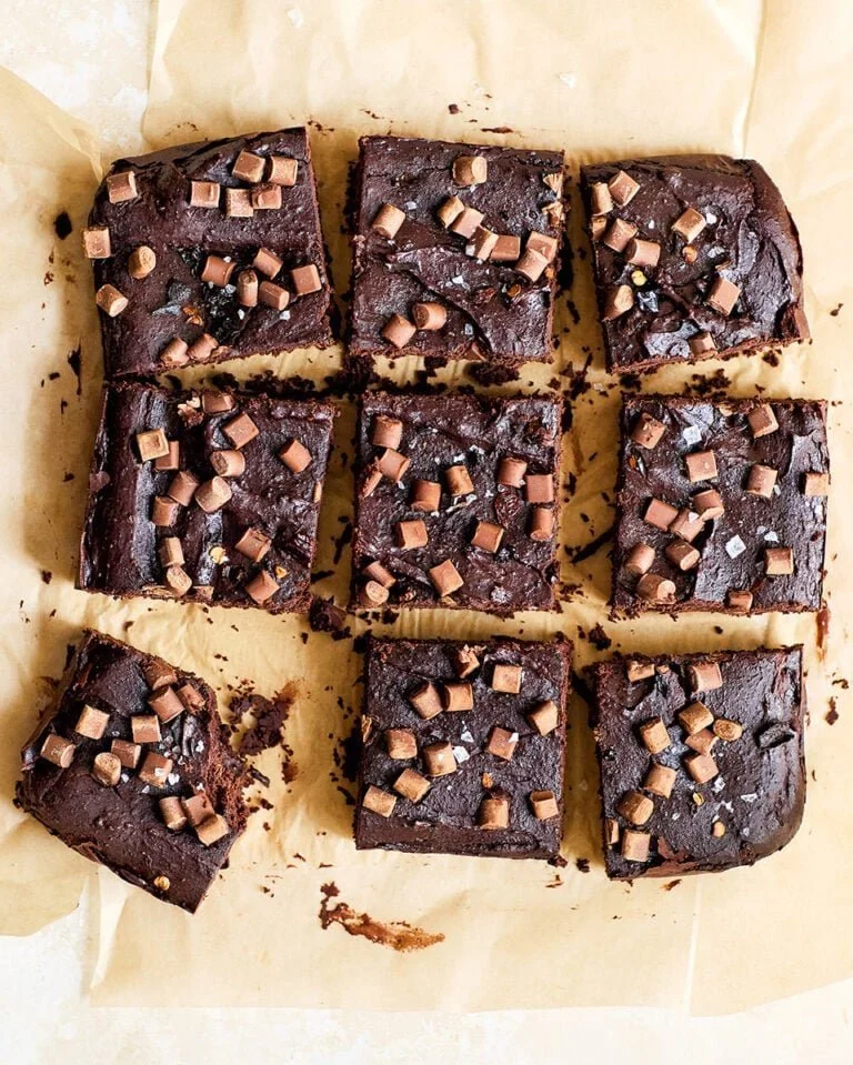 Delicious black bean brownies topped with chocolate chips on a wooden table