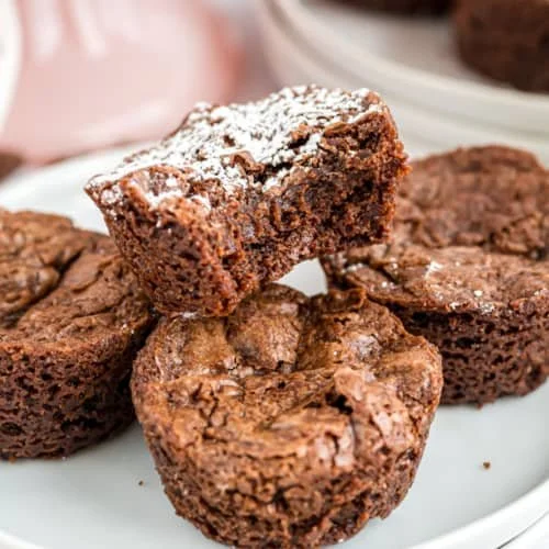 Delicious brownie bites served on a plate with chocolate drizzle
