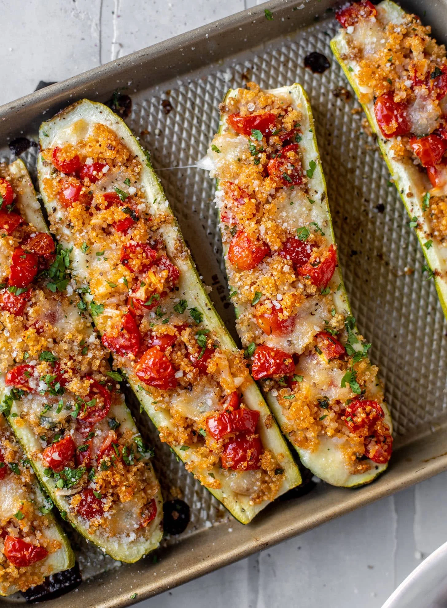 Bruschetta Quinoa Zucchini Boats topped with fresh ingredients