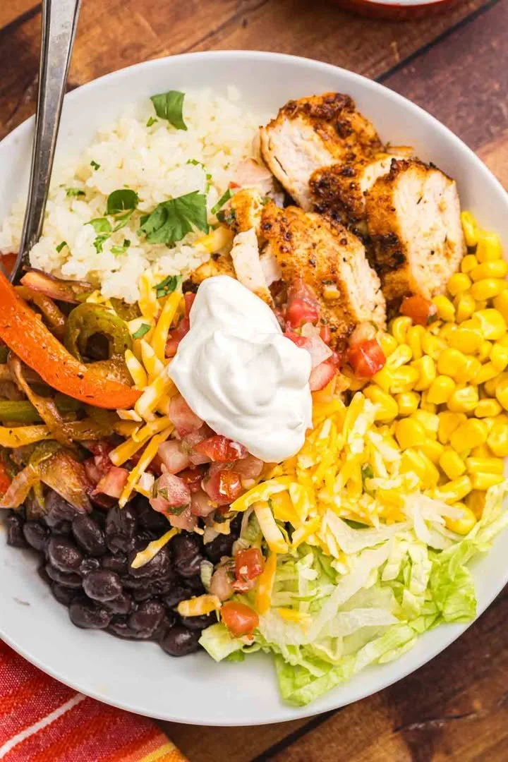 Cajun grilled chicken burrito bowl with fresh veggies and rice