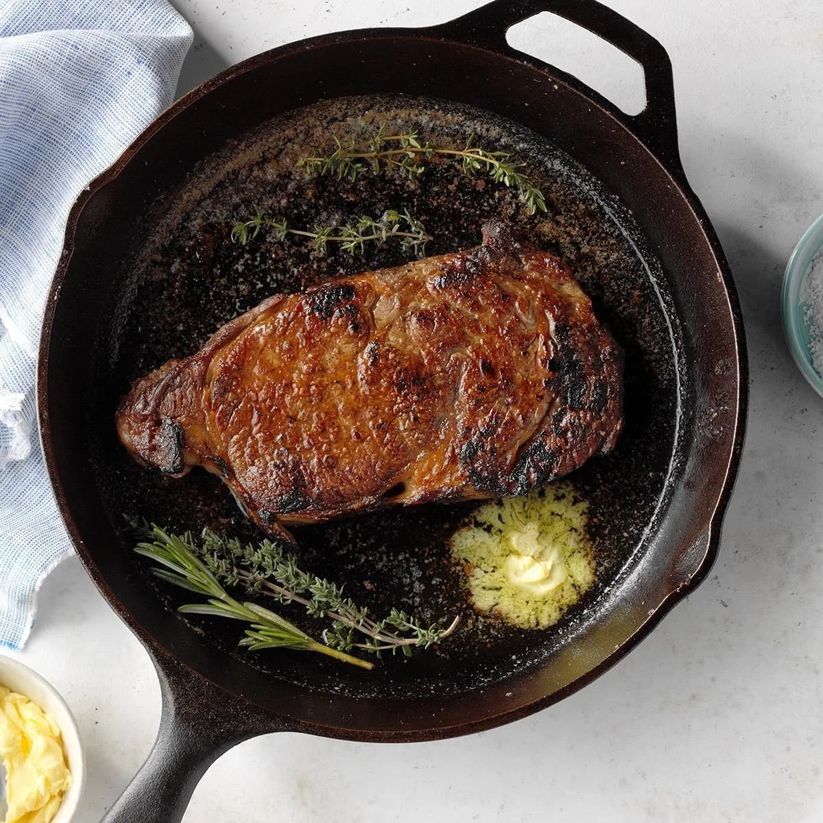 Perfectly cooked cast-iron steak on a grill with seasonings