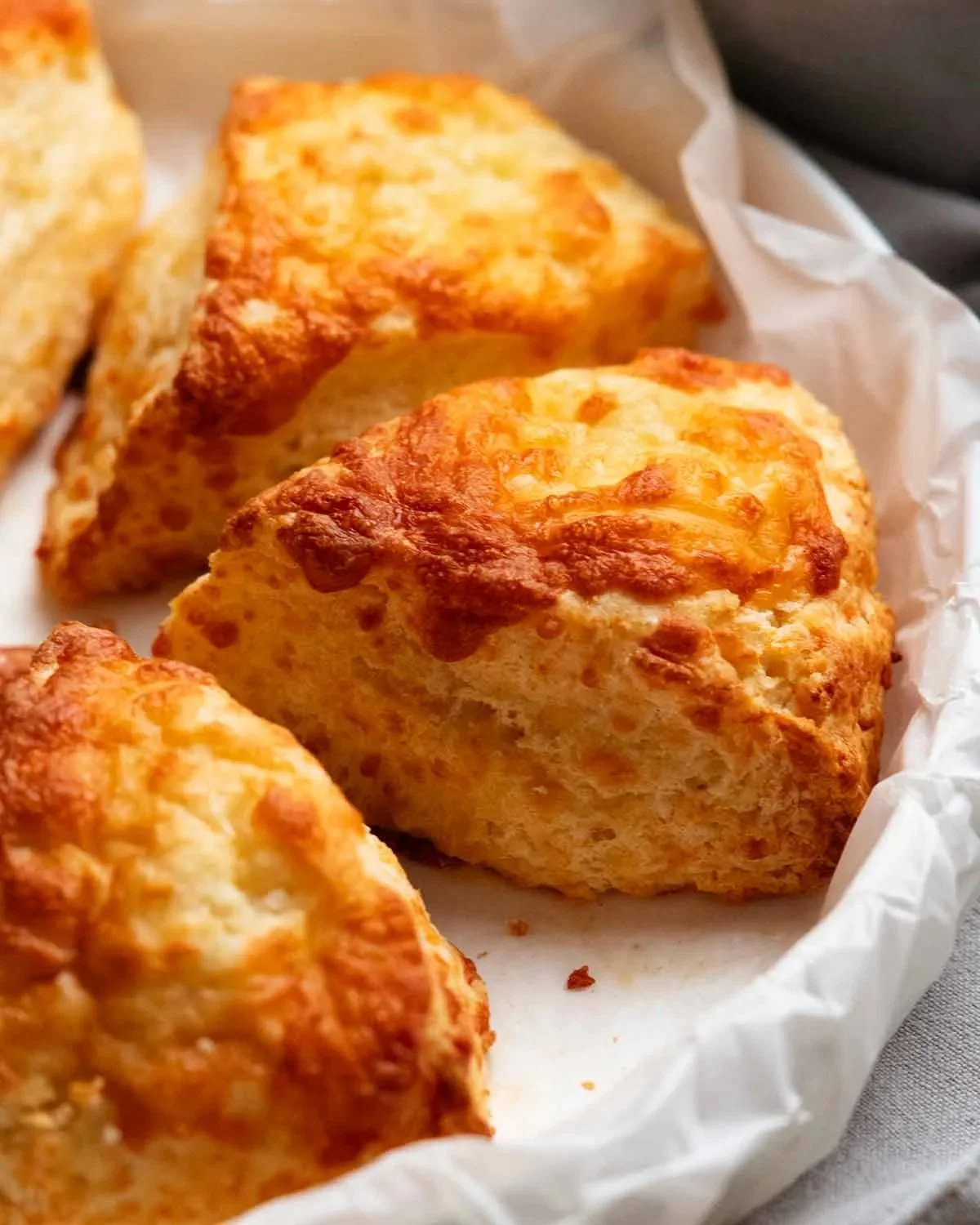 Golden brown cheese scones fresh out of the oven, topped with melted cheese.