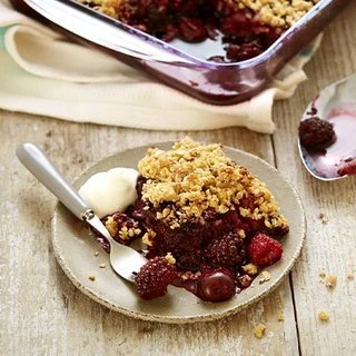 Delicious Cherry Berry Crumble dessert topped with berries and a golden crumble.