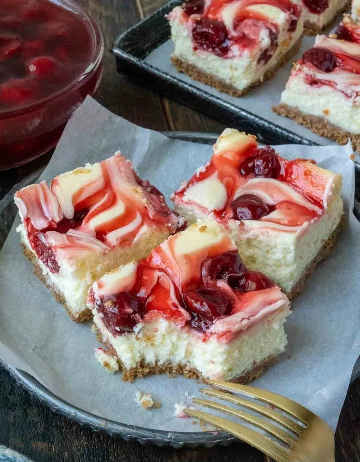 Delicious cherry cheesecake bars ready to serve on a plate.