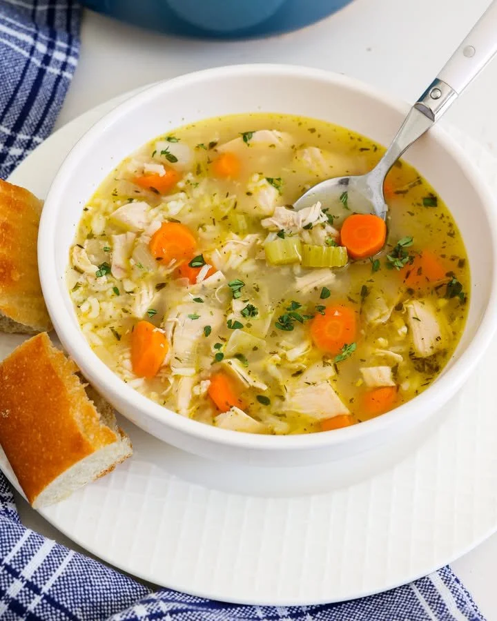 Bowl of chicken and rice soup with vegetables and herbs