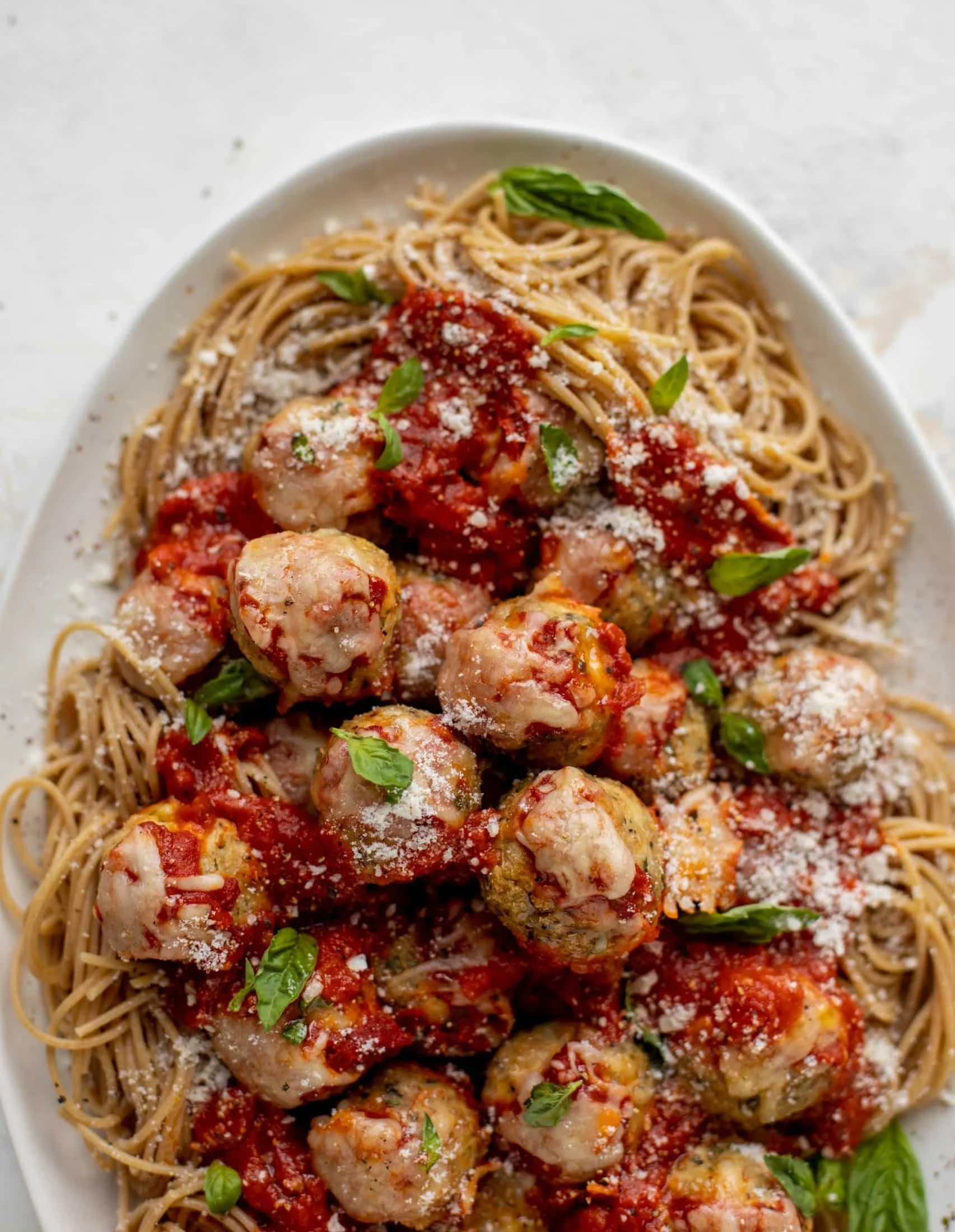 Chicken Parmesan Meatballs with roasted garlic spaghetti on a plate