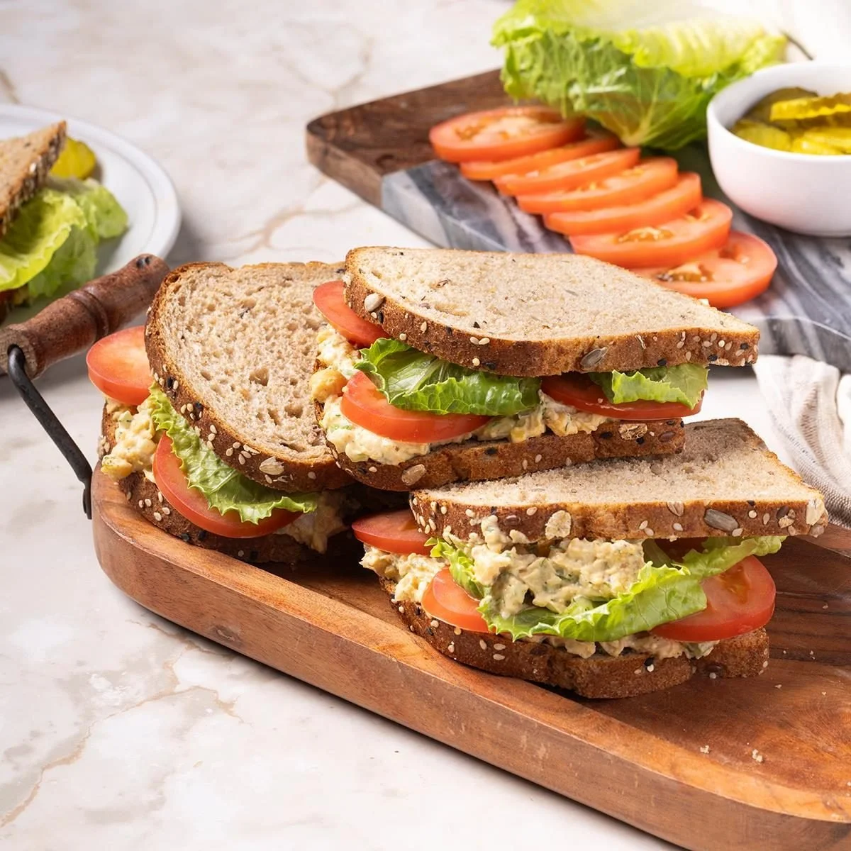 Chickpea salad sandwiches on a plate with fresh vegetables