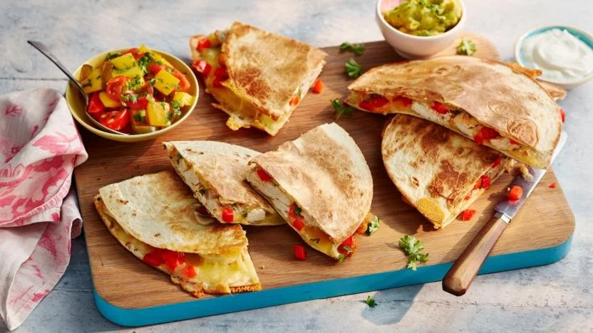 Colorful chicken and cheese quesadillas on a plate with fresh ingredients