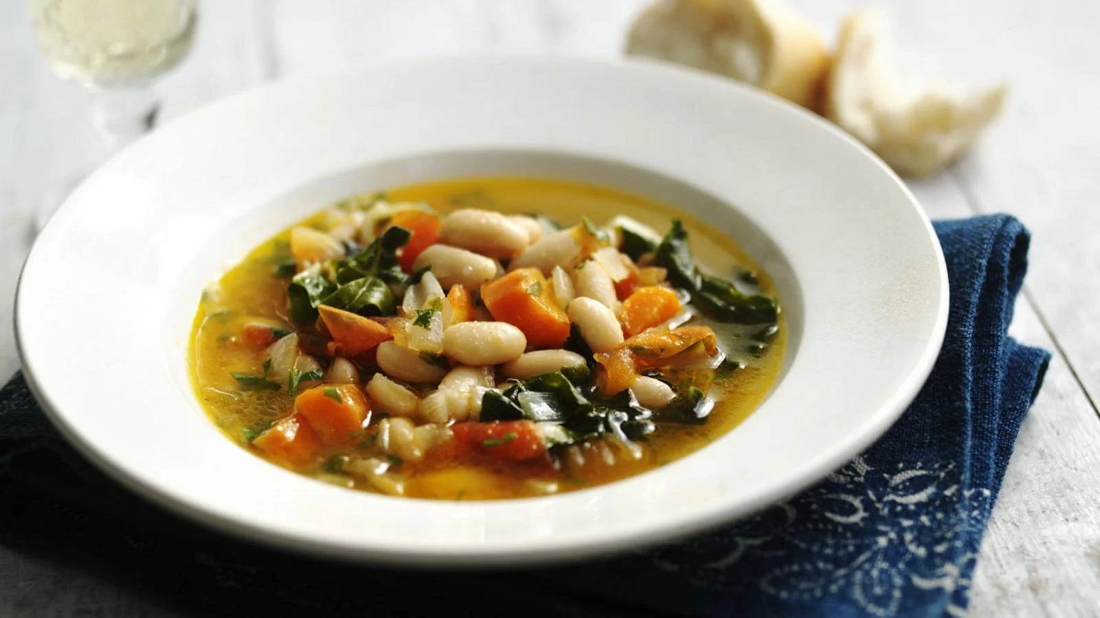 A bowl of cozy bean soup garnished with herbs and spices