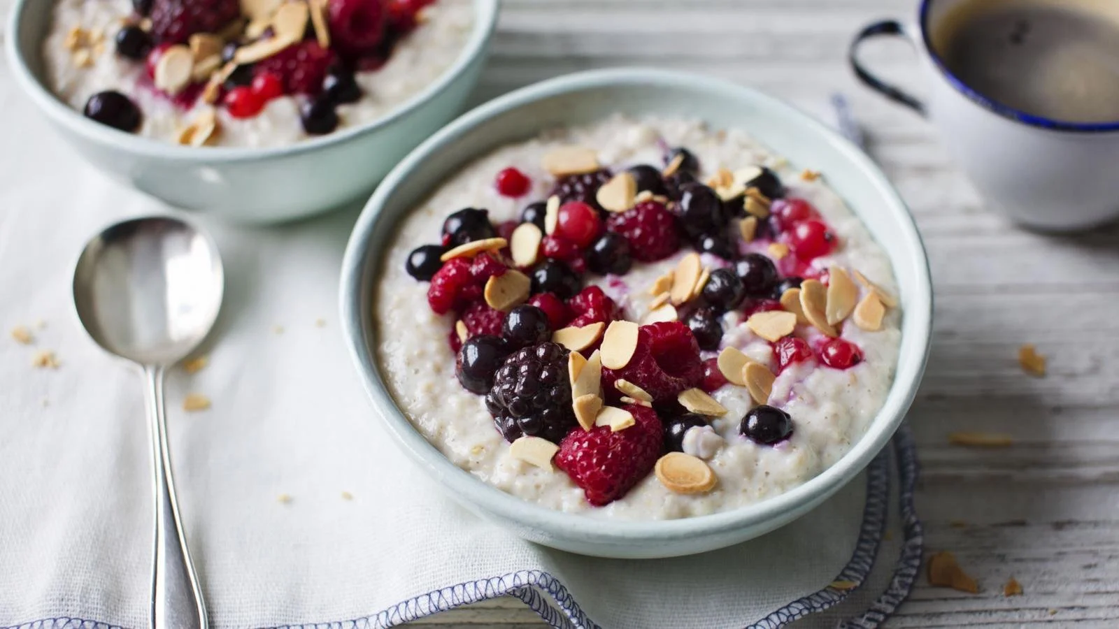 Bowl of creamy porridge topped with berries and almonds for breakfast