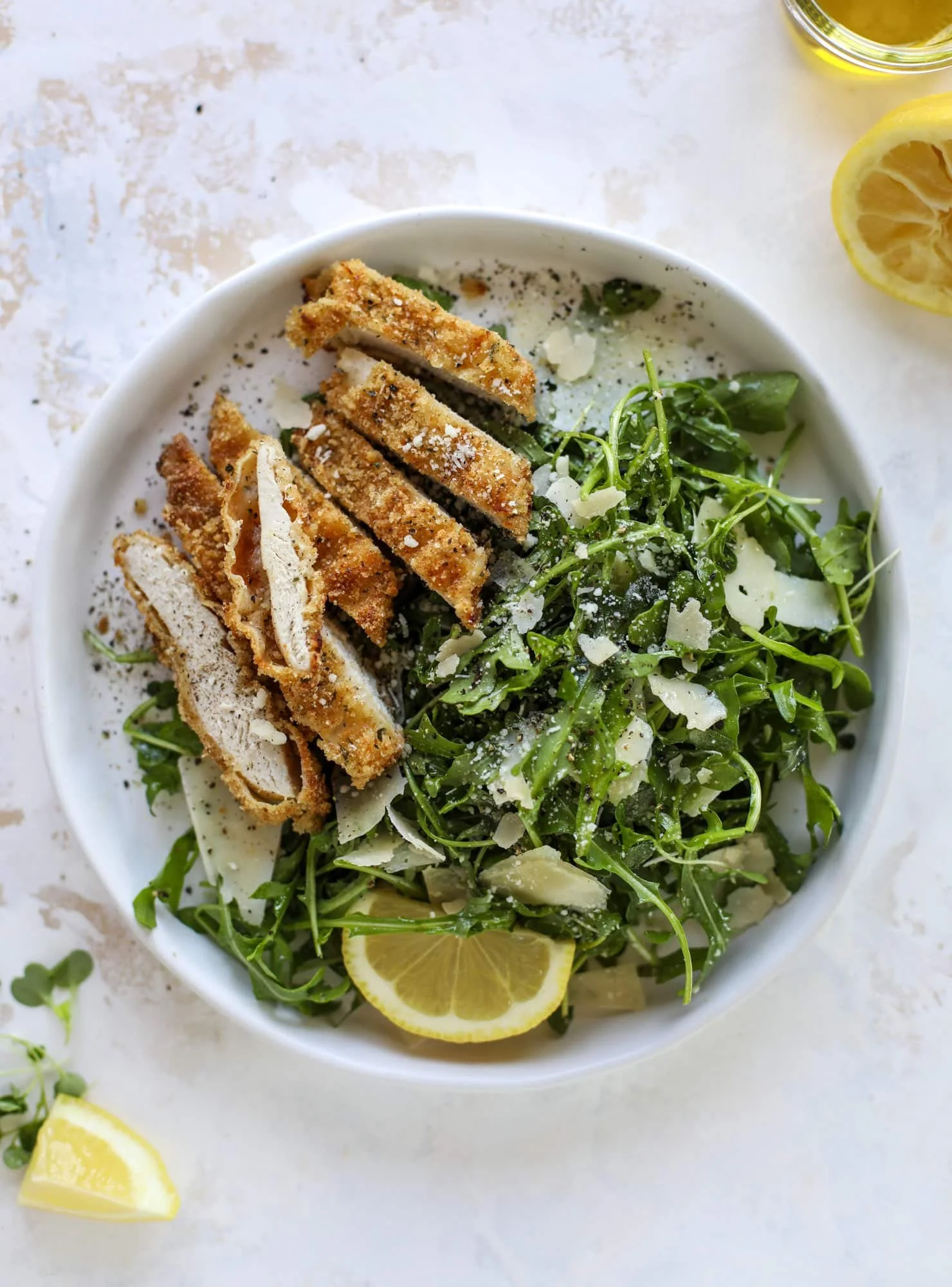 Crispy baked parmesan chicken served with lemon arugula salad