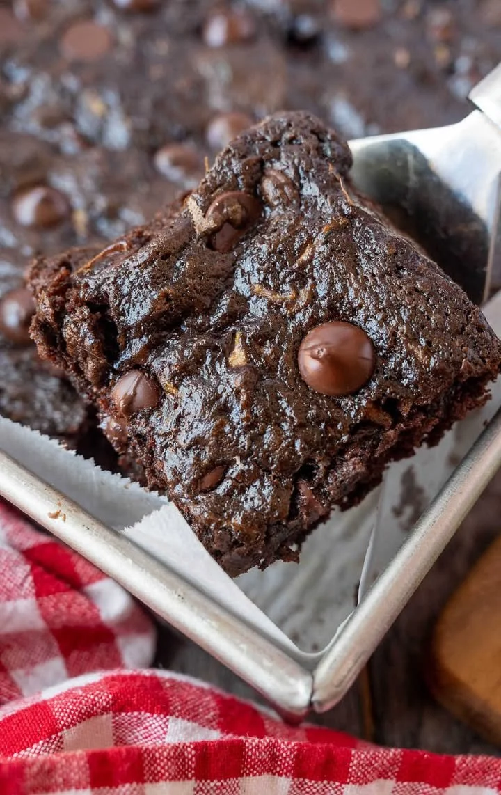 Delicious double chocolate zucchini brownies topped with cocoa powder.