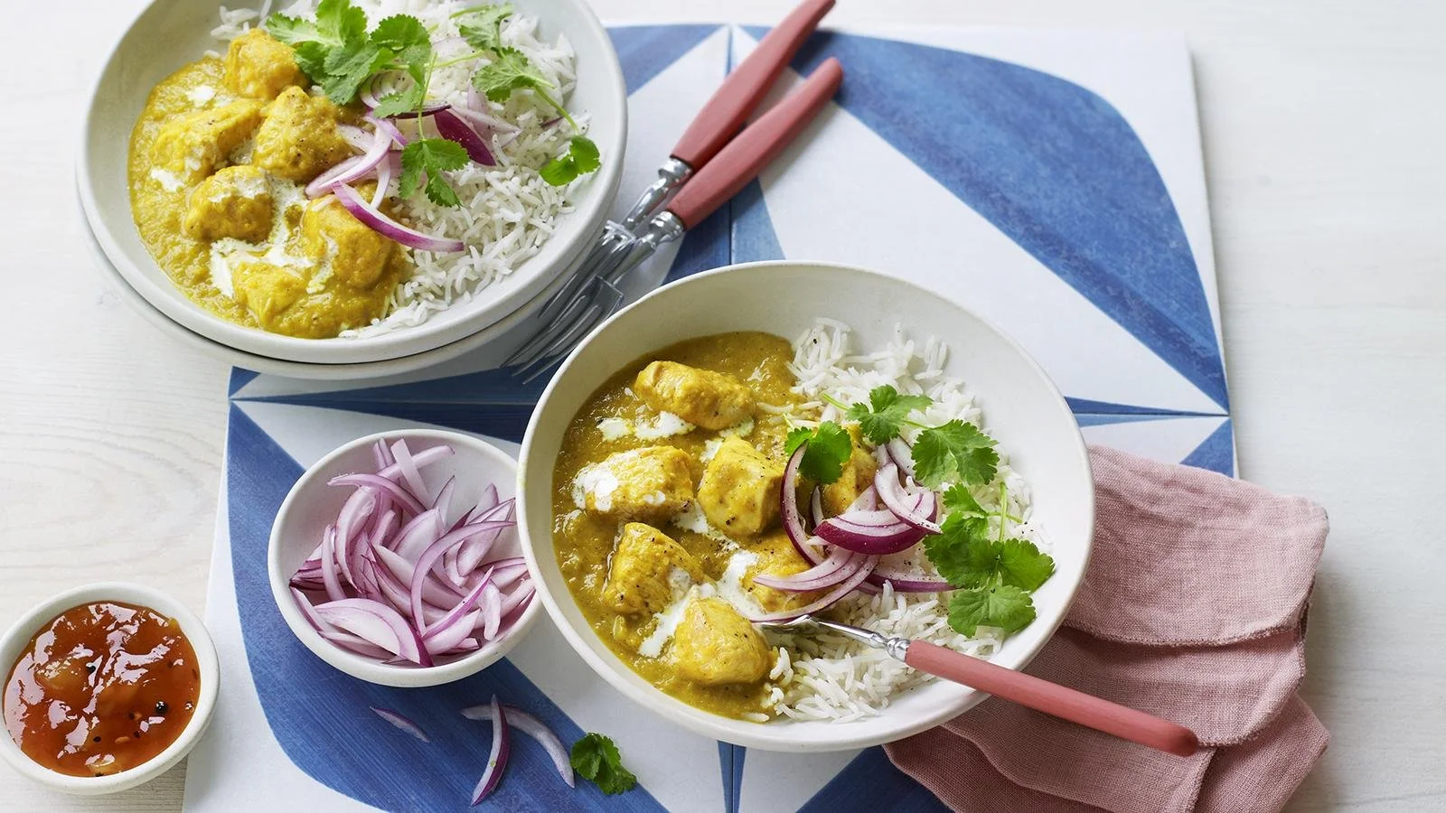 Delicious chicken korma served with rice and garnished with cilantro.