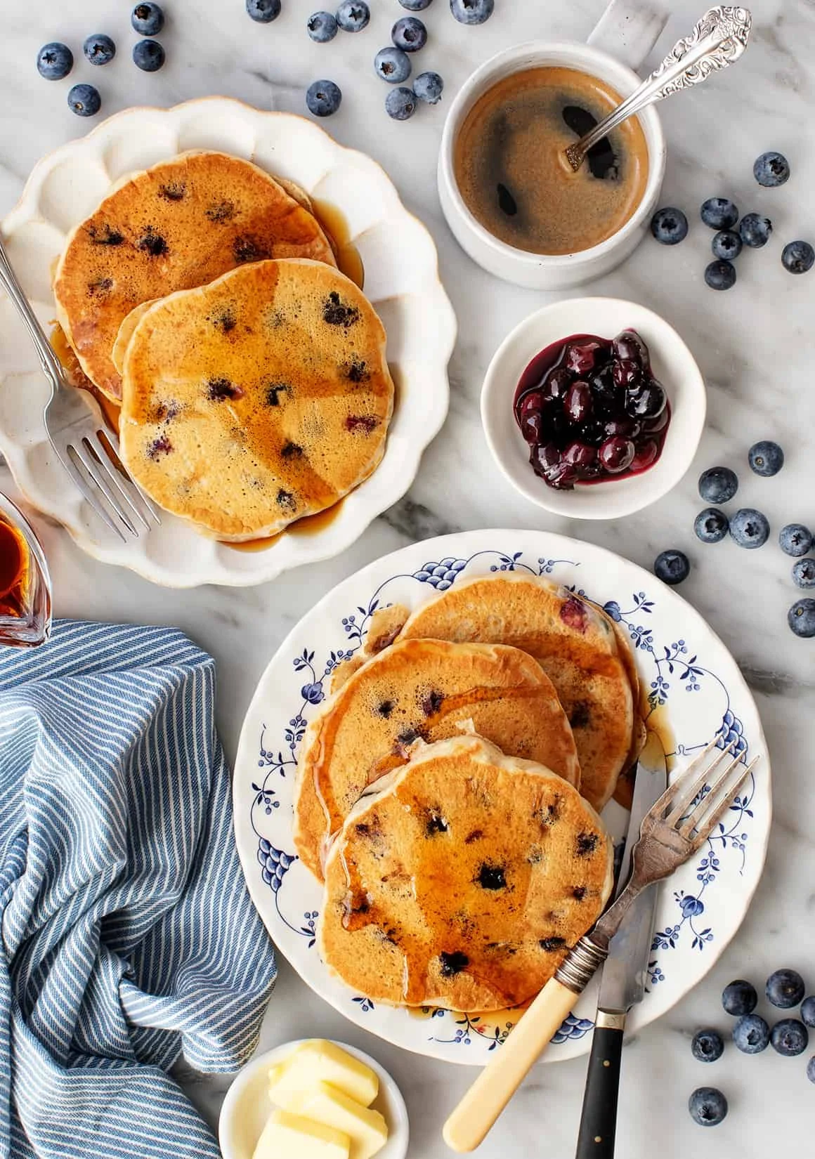 Delicious fluffy blueberry pancakes served with syrup and fresh blueberries