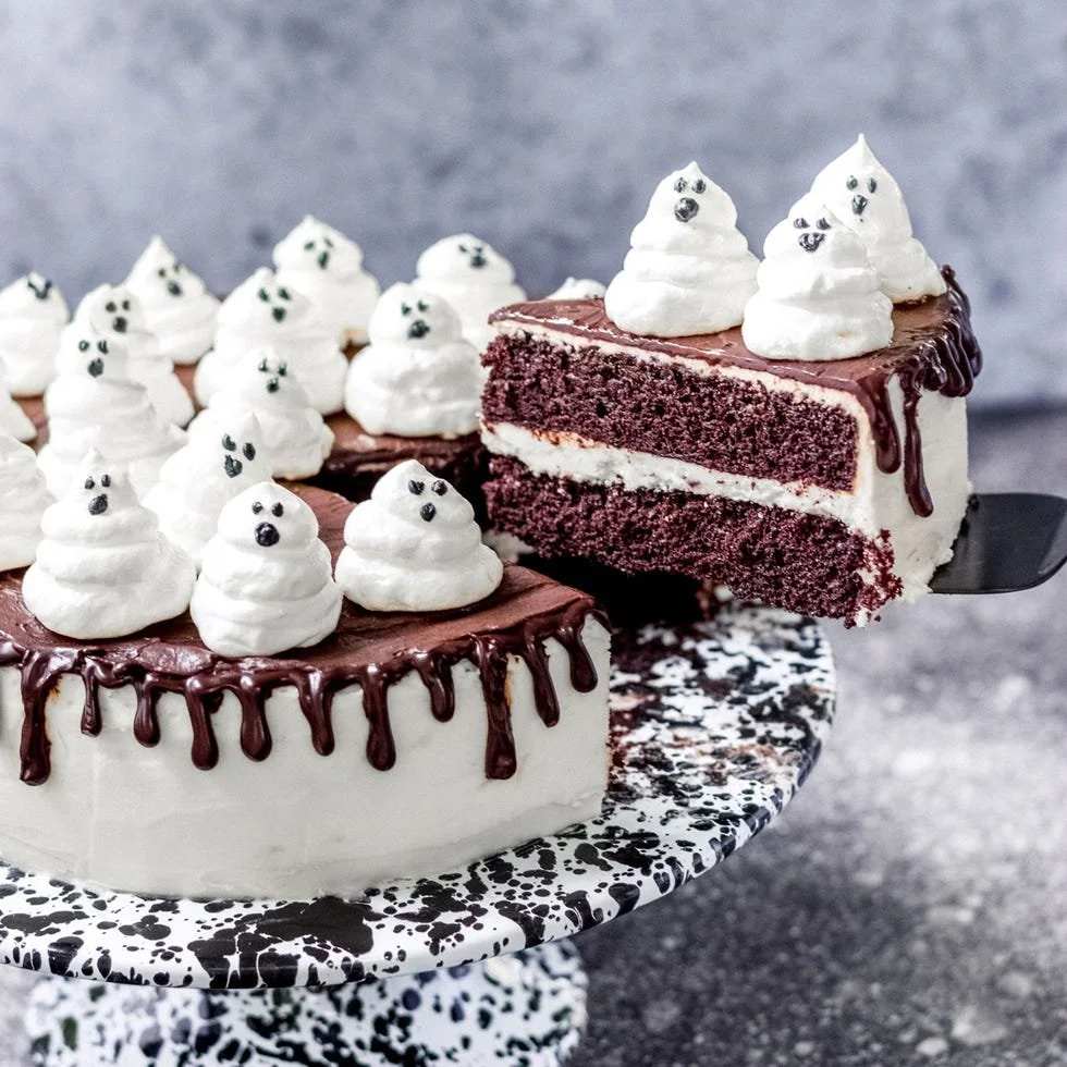 Halloween ghost cake decorated with spooky eyes and a fluffy white icing