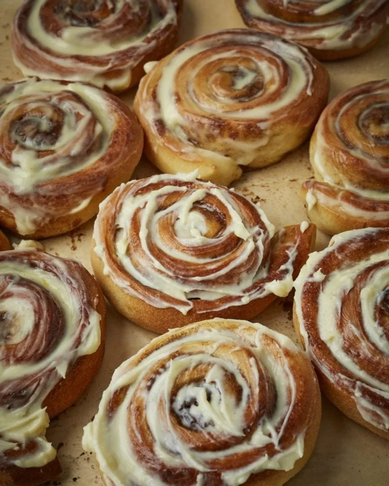 Freshly baked iced cinnamon rolls with creamy icing on top.