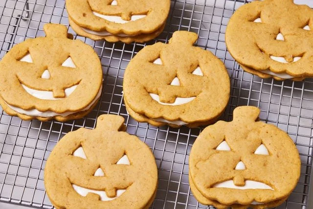 Festive Jack-O'-Lantern sandwich cookies decorated for Halloween