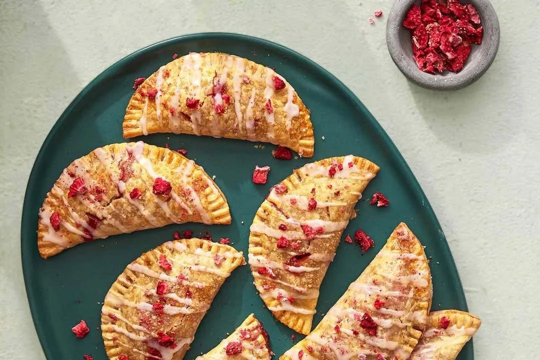 Freshly baked jammy hand pies with fruit filling on a cooling rack