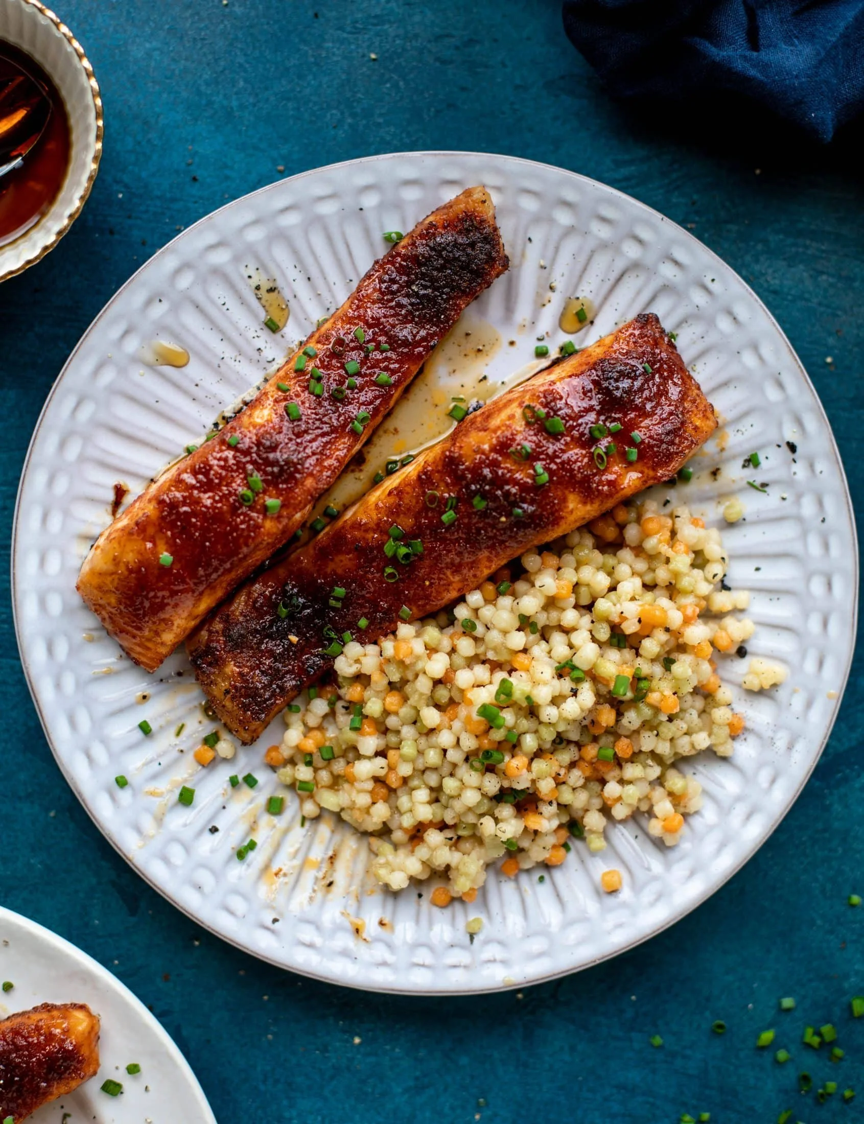 Maple BBQ Salmon served with brown butter couscous on a plate.