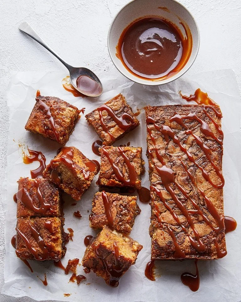 Delicious miso caramel blondies topped with a drizzle of caramel sauce.
