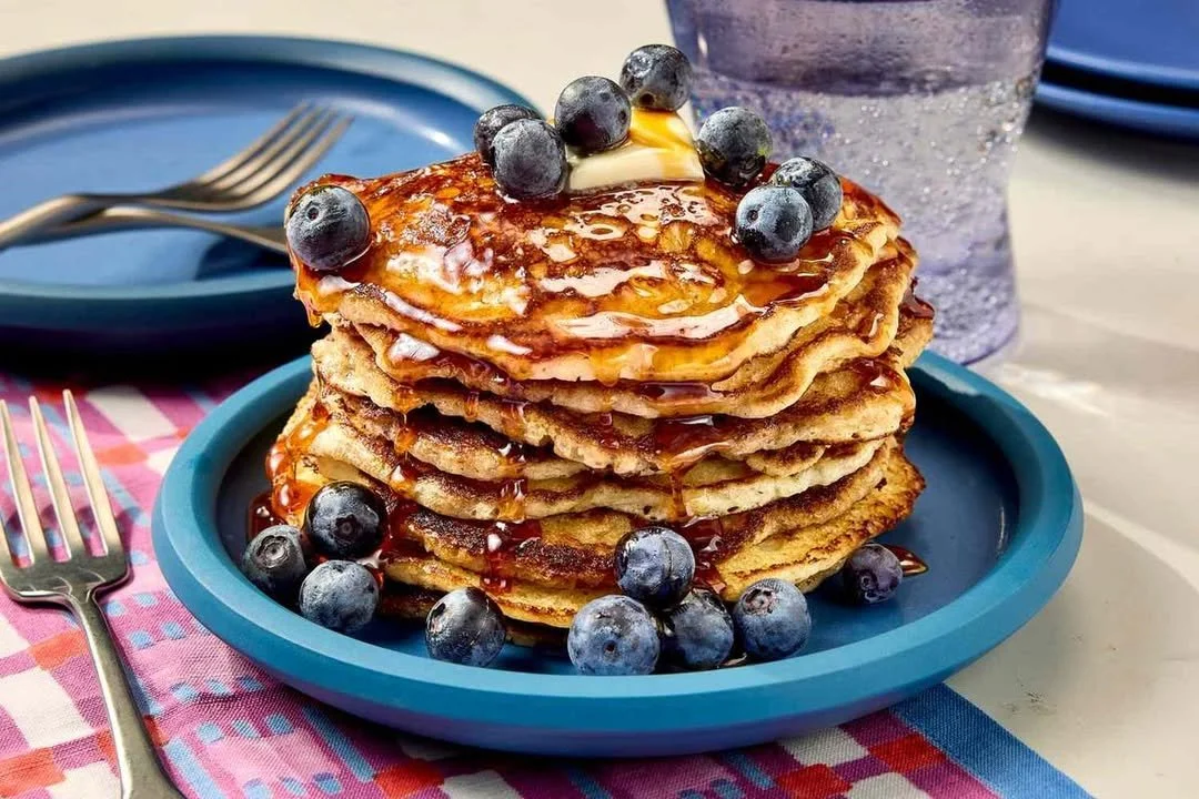 Fluffy muffin mix pancakes served with syrup and berries on a plate.