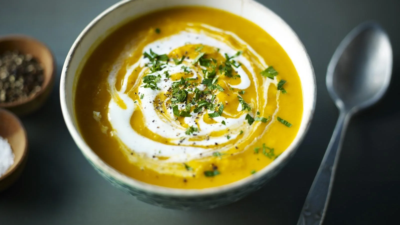 Bowl of rich and flavorful Mulligatawny Soup garnished with herbs.