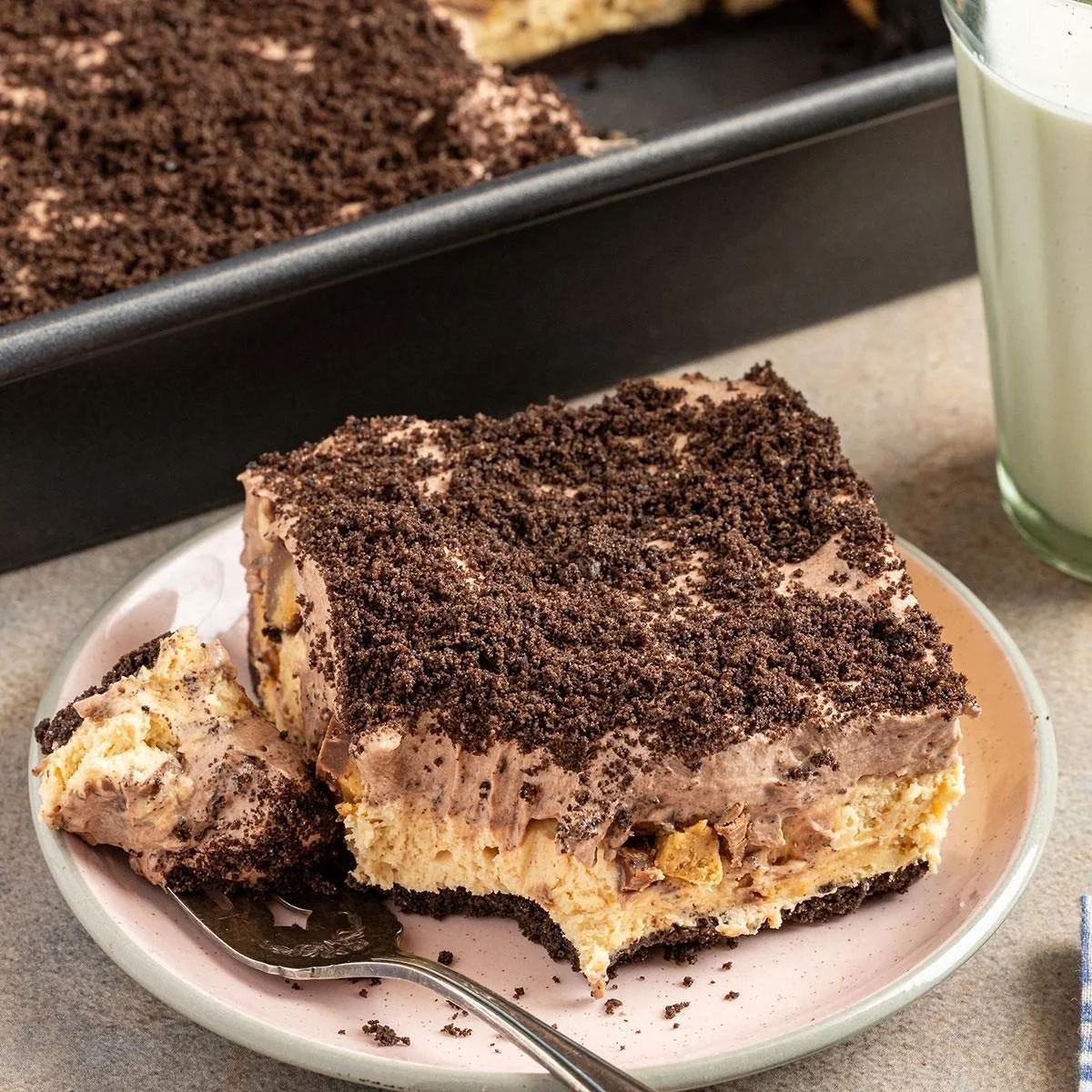 Delicious peanut butter chocolate dessert topped with creamy frosting and chocolate drizzle.