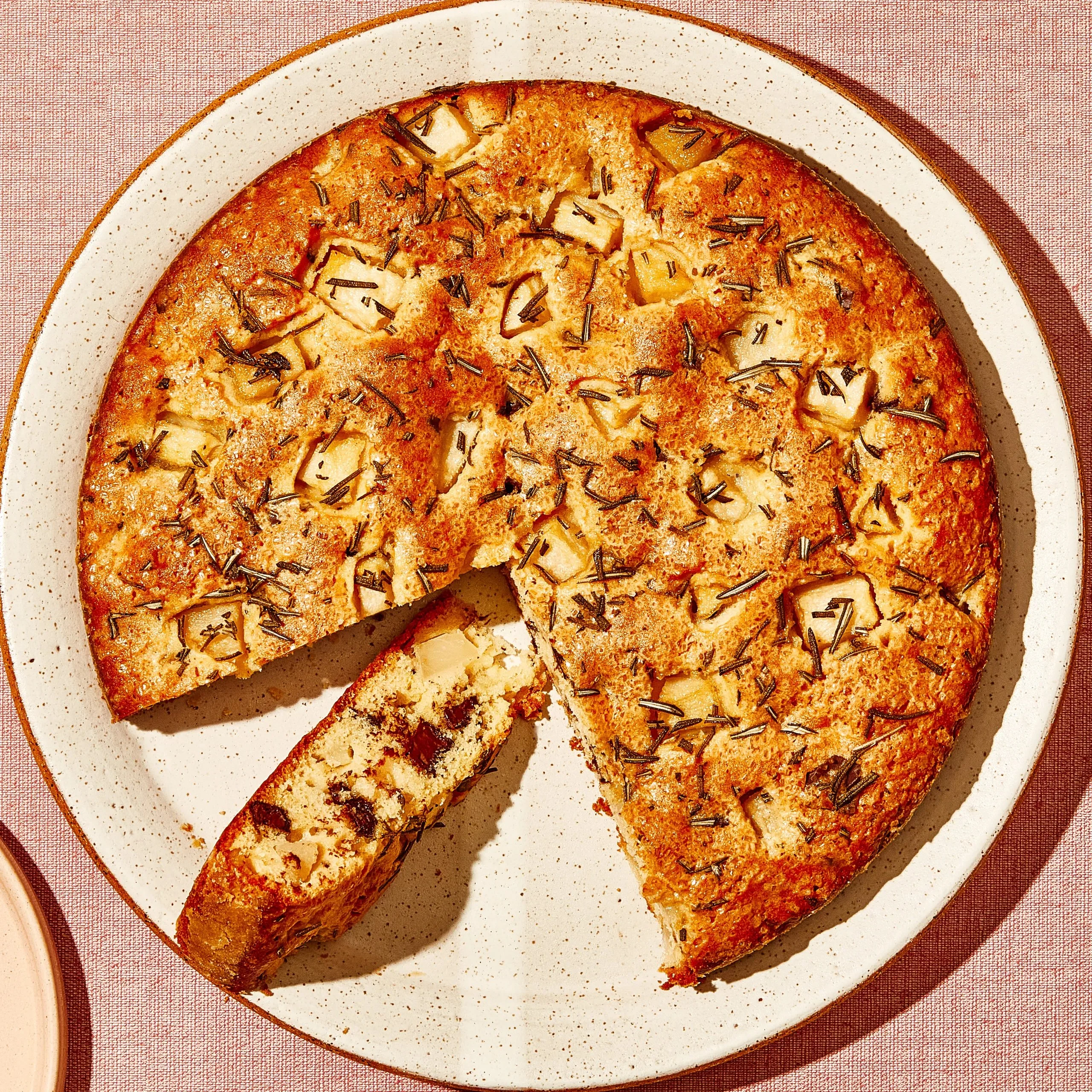 Delicious pear snacking cake topped with chocolate and rosemary for a sweet treat.