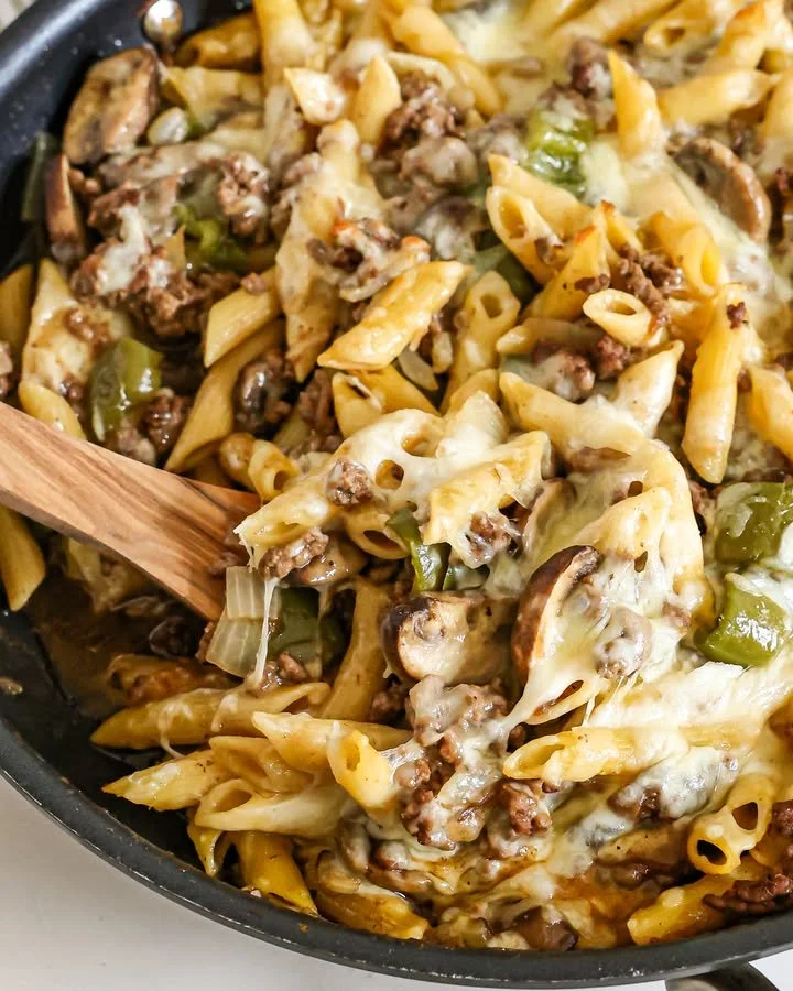 A bowl of creamy Philly Cheesesteak Pasta with beef, peppers, and cheese.