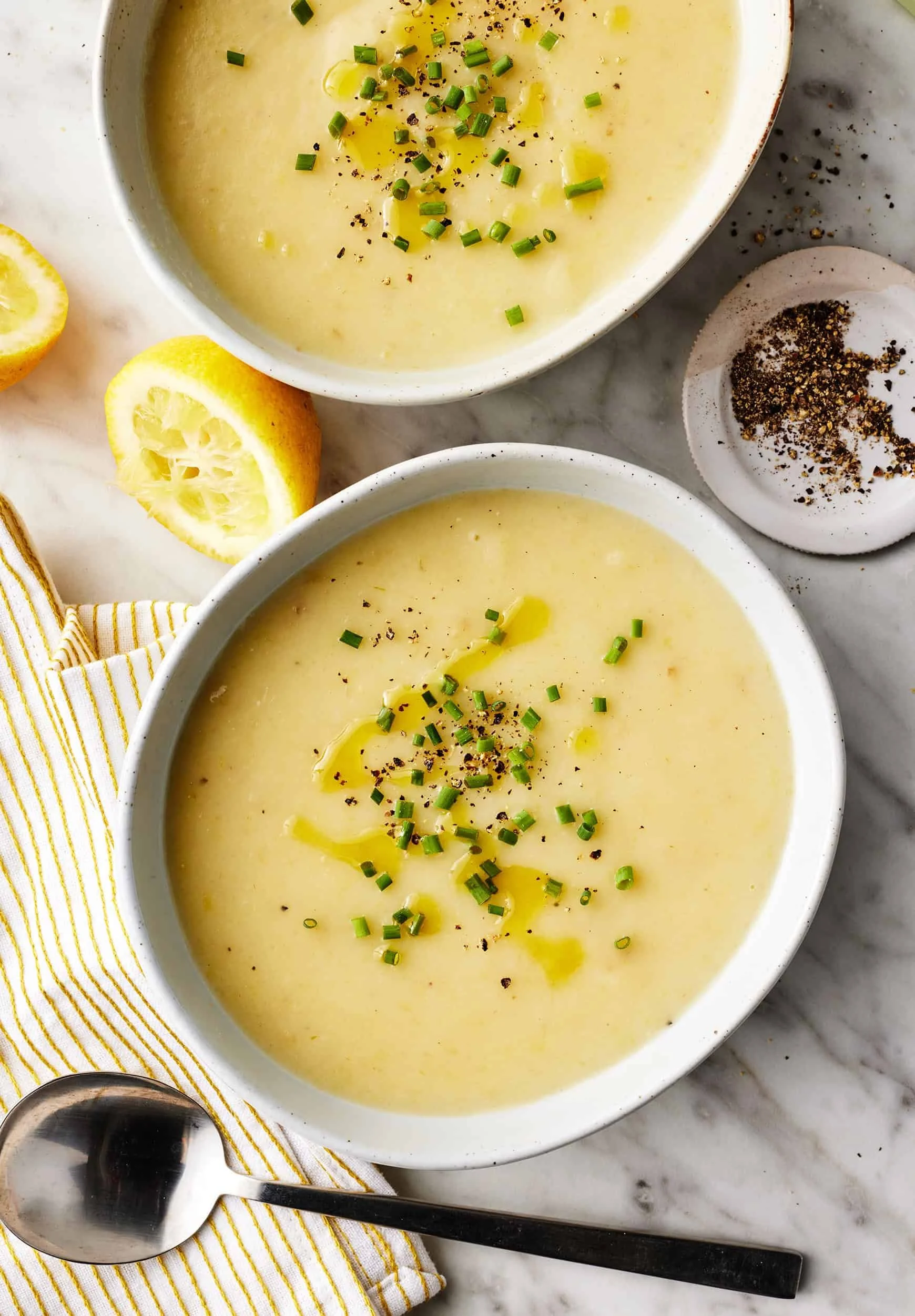 Bowl of creamy Potato Leek Soup garnished with fresh herbs.