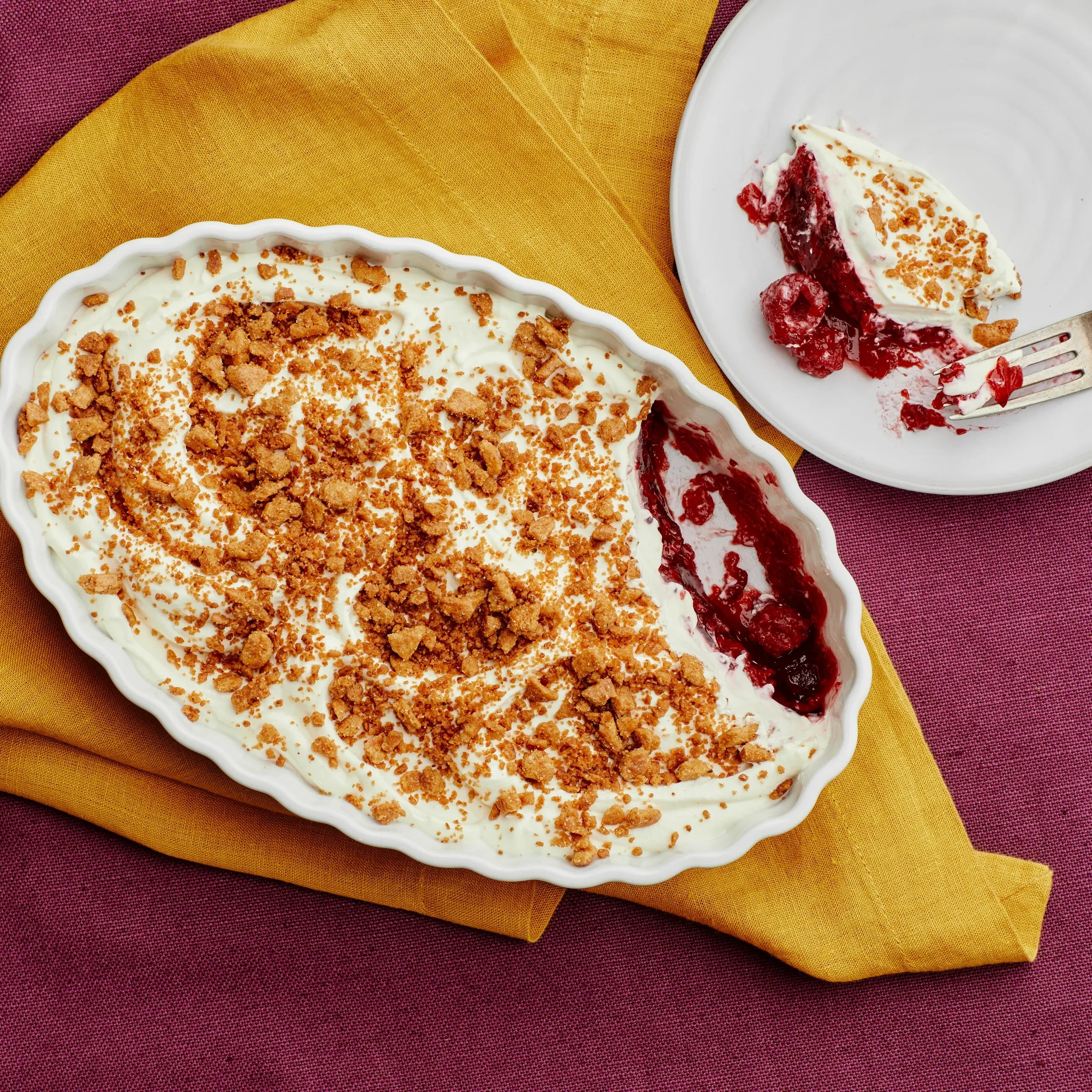 A delicious Raspberry Jell-O salad served in a bowl, garnished with fresh raspberries.