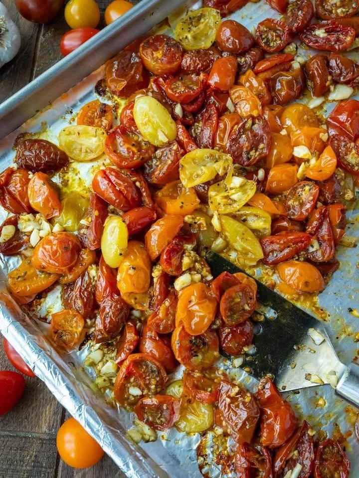Plate of roasted cherry tomatoes garnished with herbs