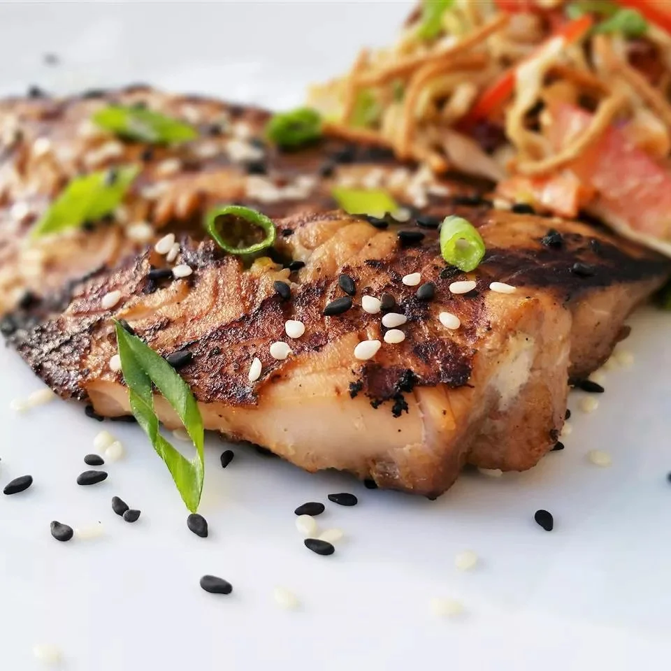 Sesame grilled salmon on a plate garnished with vegetables