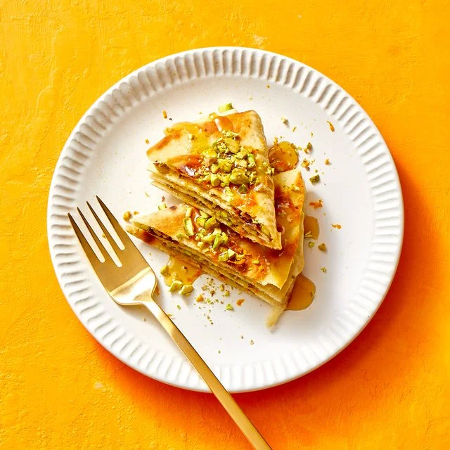 Plate of homemade shortcut baklava wedges with nuts and honey glaze