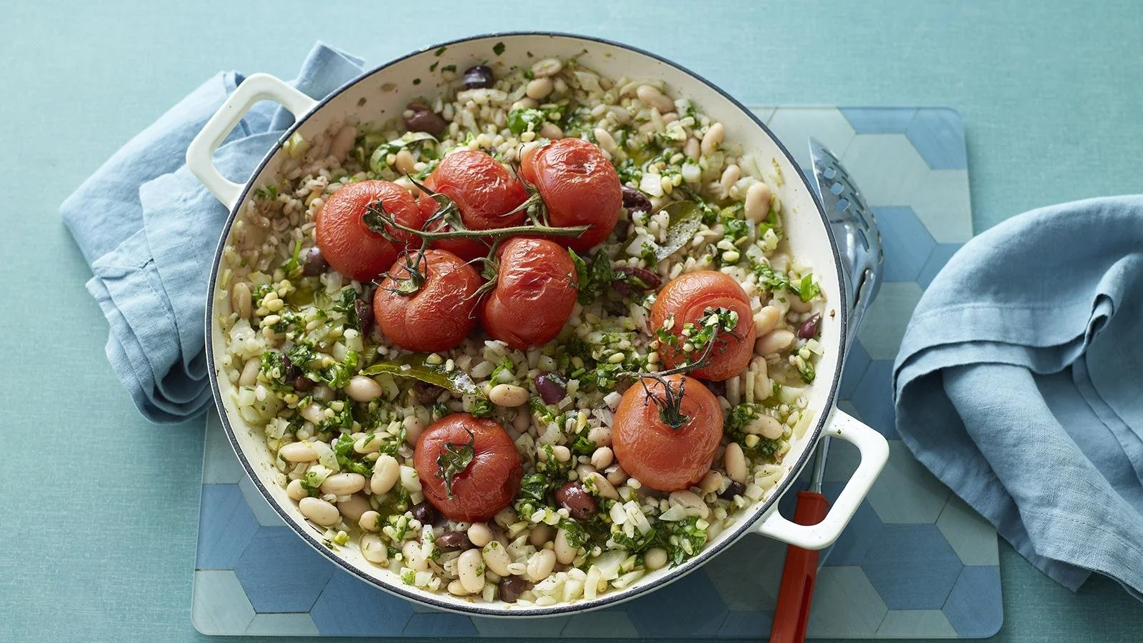 A bowl of slow-cooked tomato and fennel stew with pearl barley garnished with herbs.