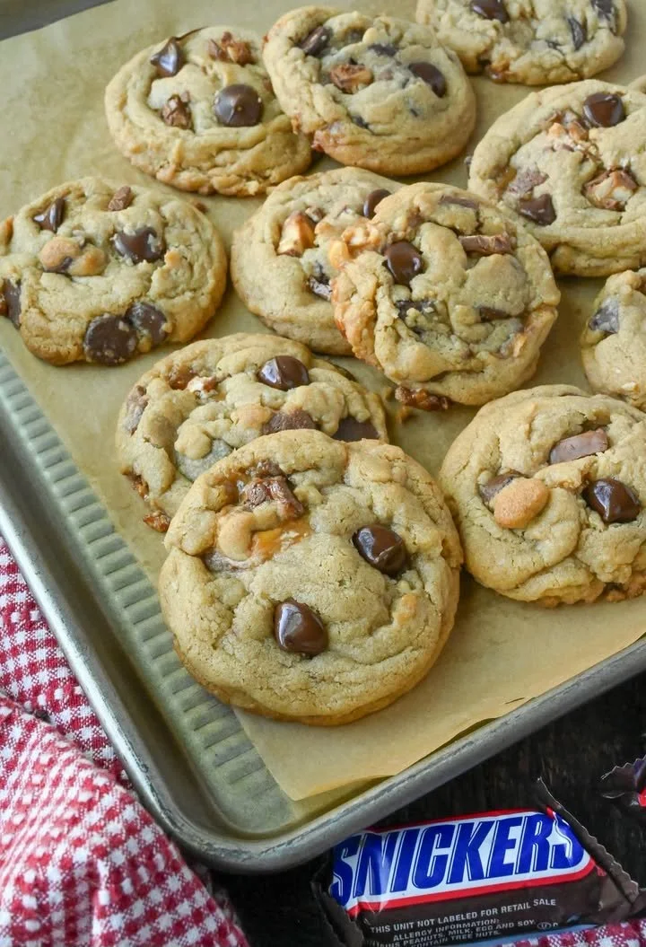 Freshly baked Snickers cookies with chocolate chunks and caramel.