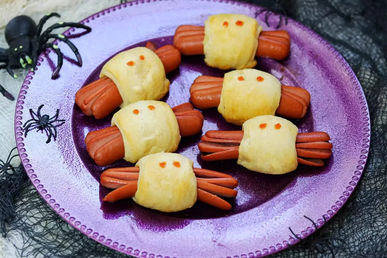 Spooky spider Halloween hot dogs served on a platter for a festive party.