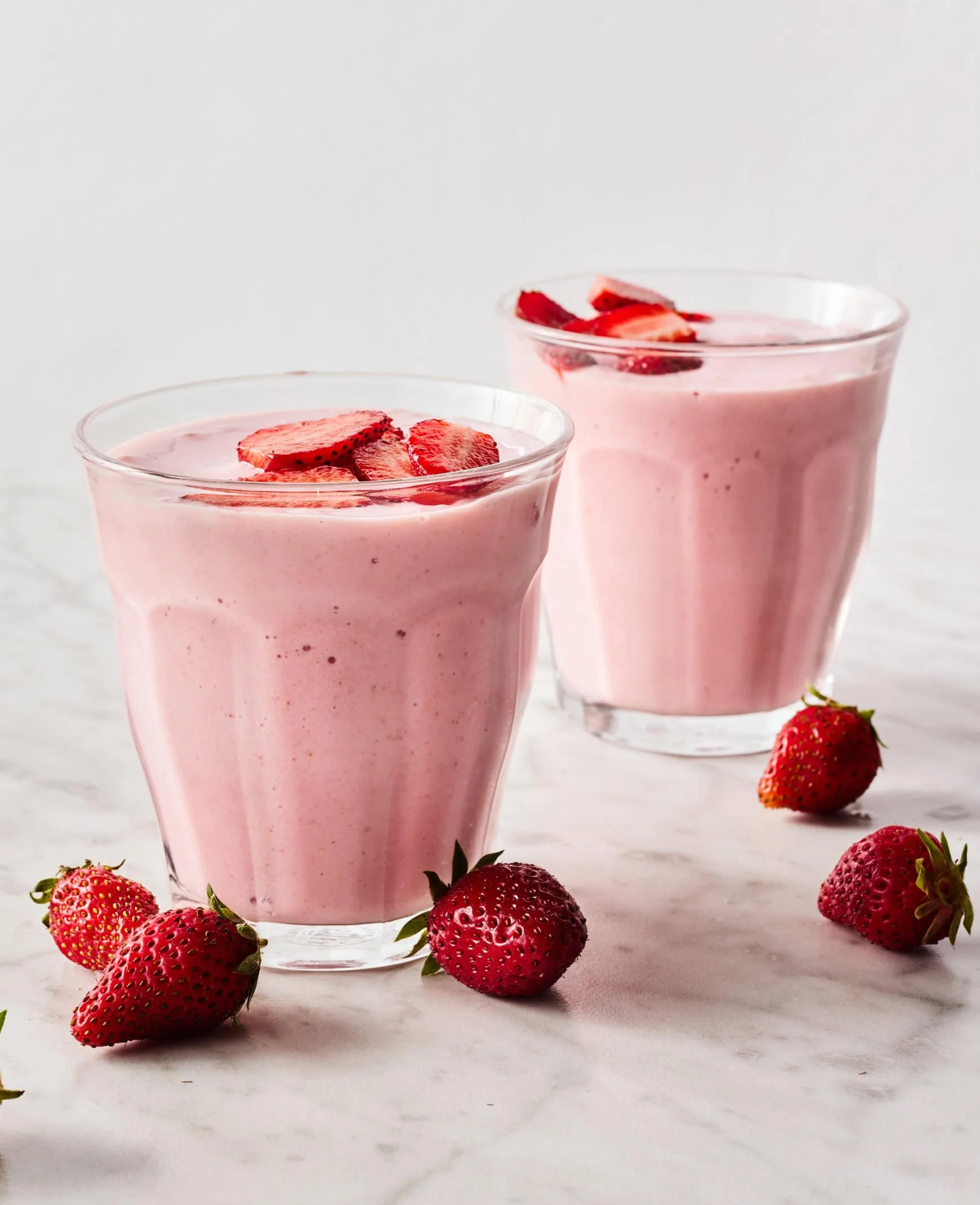 Delicious strawberry banana smoothie in a glass with fresh fruits