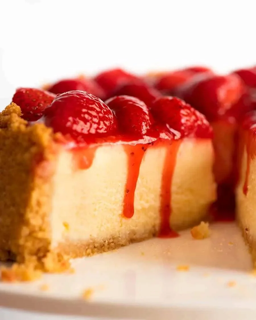 Delicious strawberry cheesecake topped with fresh strawberries and cream