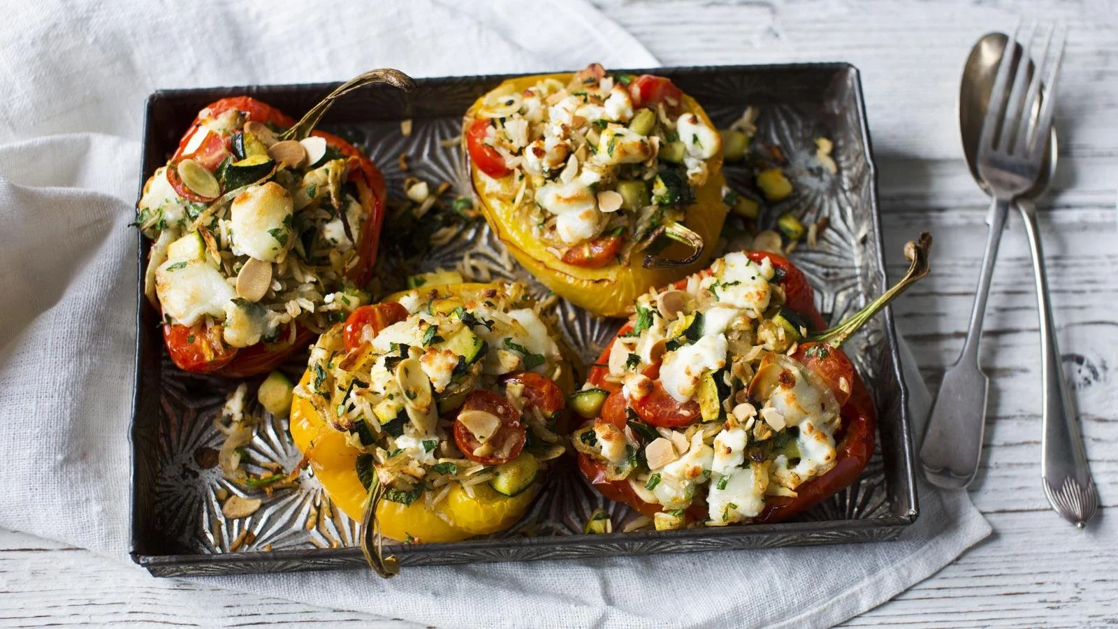 Colorful stuffed peppers filled with rice, vegetables, and spices on a plate.