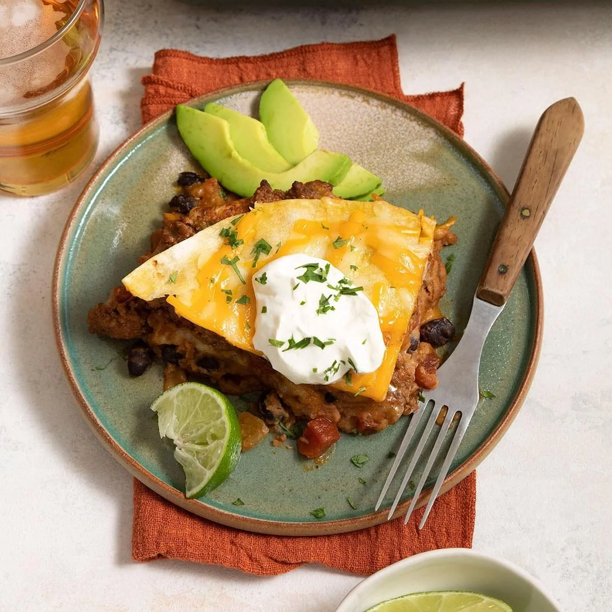 Delicious taco lasagna layered with seasoned beef, cheese, and tortillas.