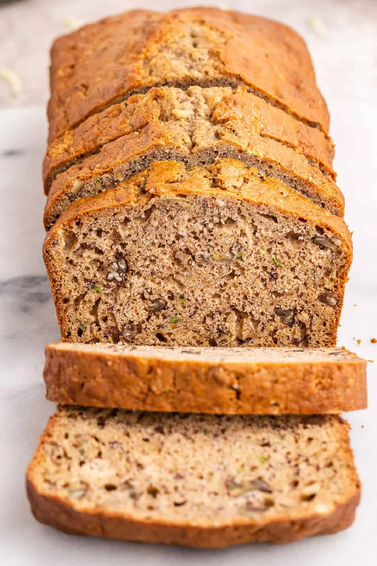 A loaf of homemade Zucchini Banana Bread, fresh out of the oven, sliced and ready to serve.