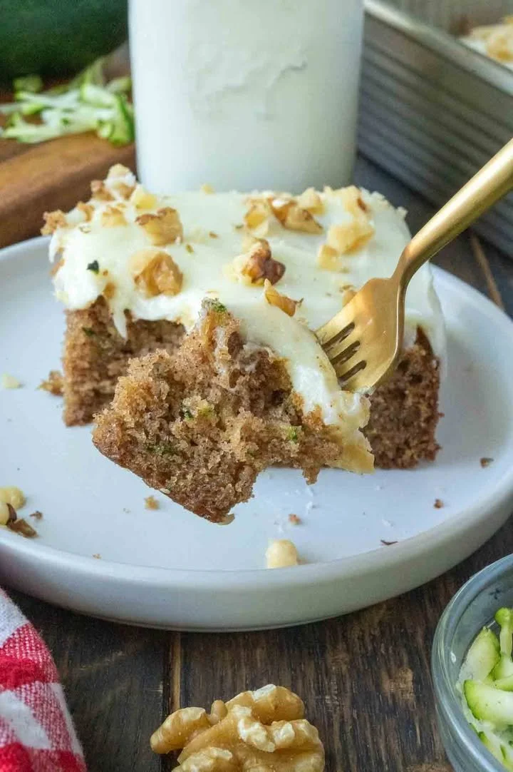 Moist zucchini cake with creamy cream cheese frosting on a dessert plate