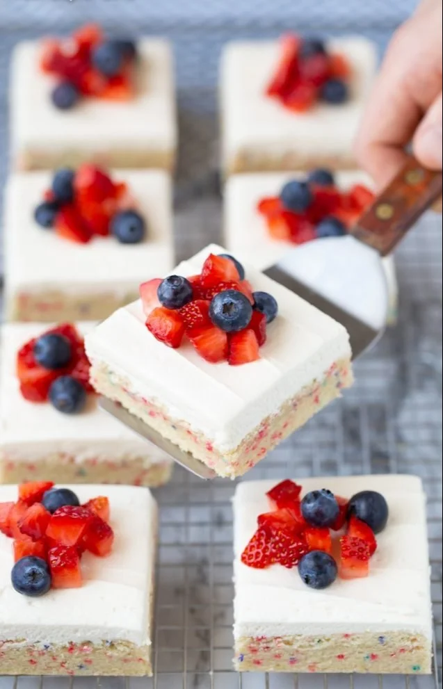 4th of July sugar cookie bars topped with vibrant sprinkles and festive decorations.