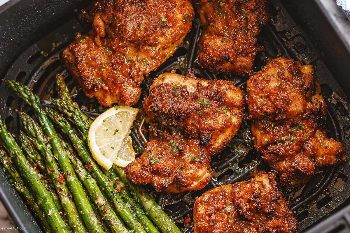 Air fryer chicken thighs served with roasted asparagus on a plate