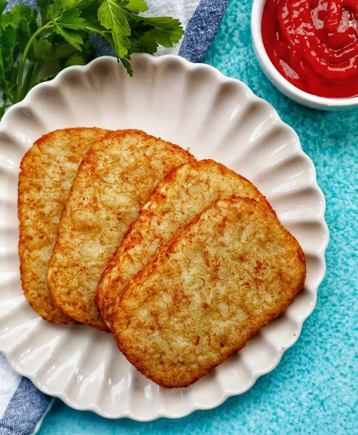 Crispy Air Fryer hash brown patties served on a plate with dipping sauce.
