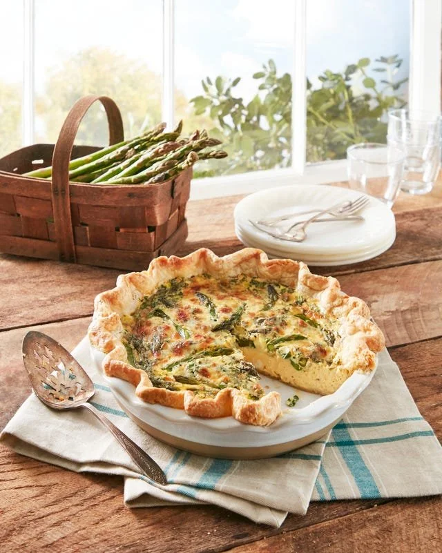 Slice of asparagus quiche showcasing fresh ingredients and golden crust.